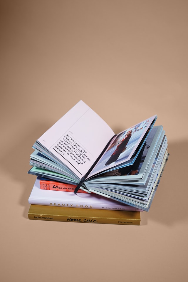 pile of selective books with one book open on top